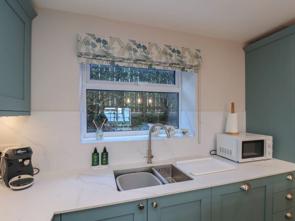 A kitchen with a sink and microwave at Cheyne Cottage in Fylingthorpe