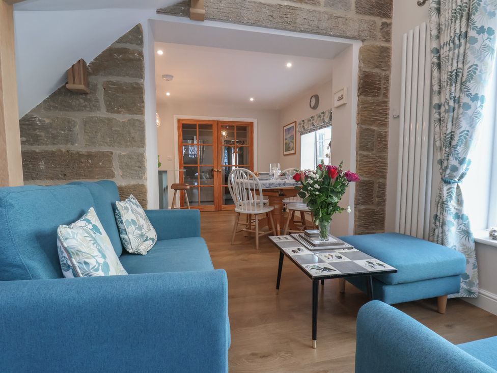 A living room with a sofa and coffee table at Cheyne Cottage in Fylingthorpe