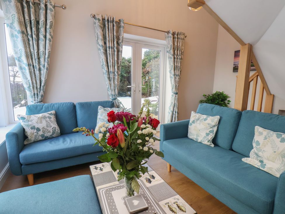 A living room with sofas and a flower arrangement at Cheyne Cottage in Fylingthorpe