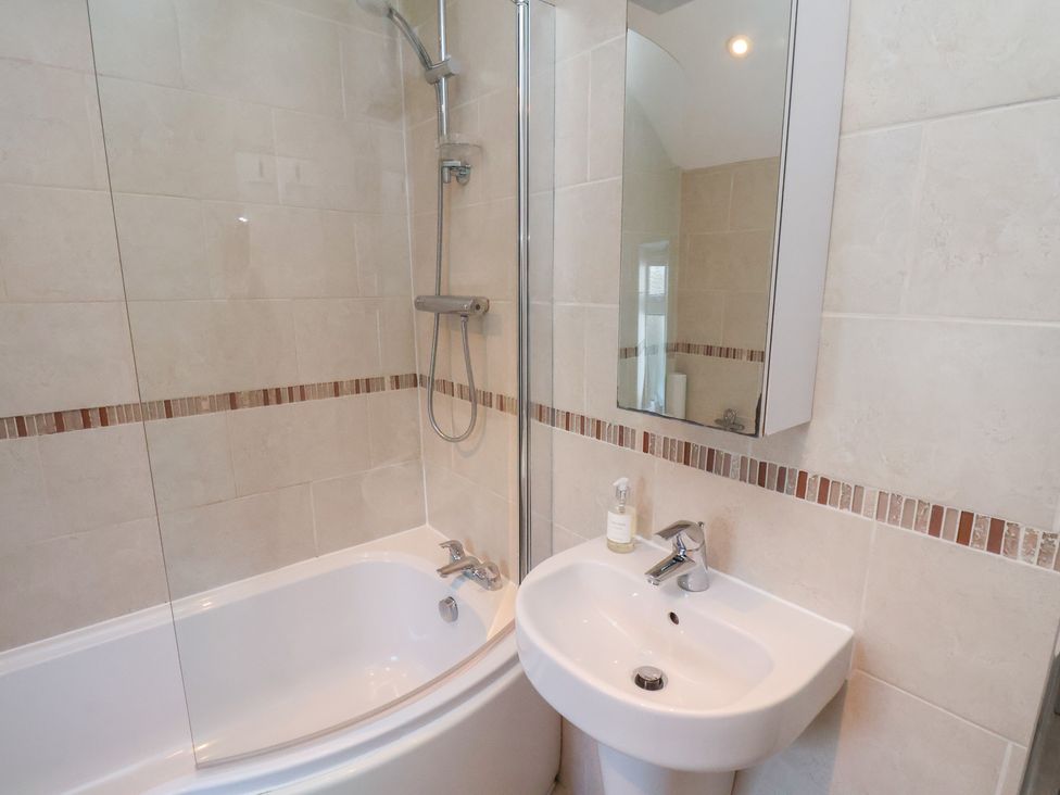 A bathroom with a shower and bathtub at Cheyne Cottage Fylingthorpe
