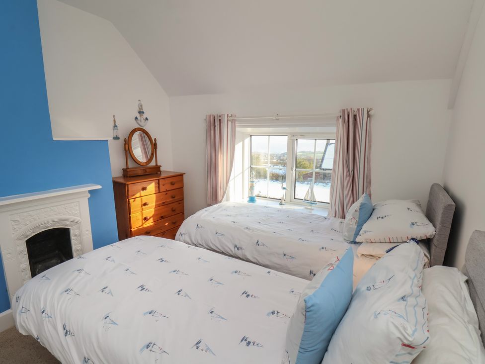 A bedroom with two beds and a window at Cheyne Cottage in Fylingthorpe