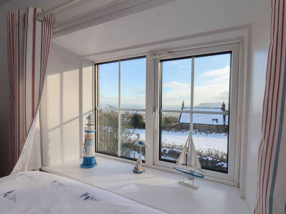 A bedroom window with figurines at Cheyne Cottage in Fylingthorpe