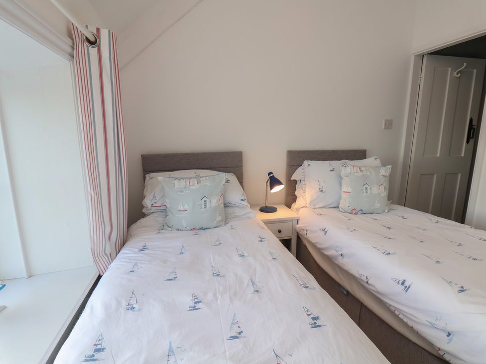 A bedroom with two beds and a lamp at Cheyne Cottage Fylingthorpe