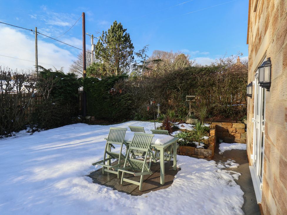 A garden with seating and snow at Cheyne Cottage in Fylingthorpe