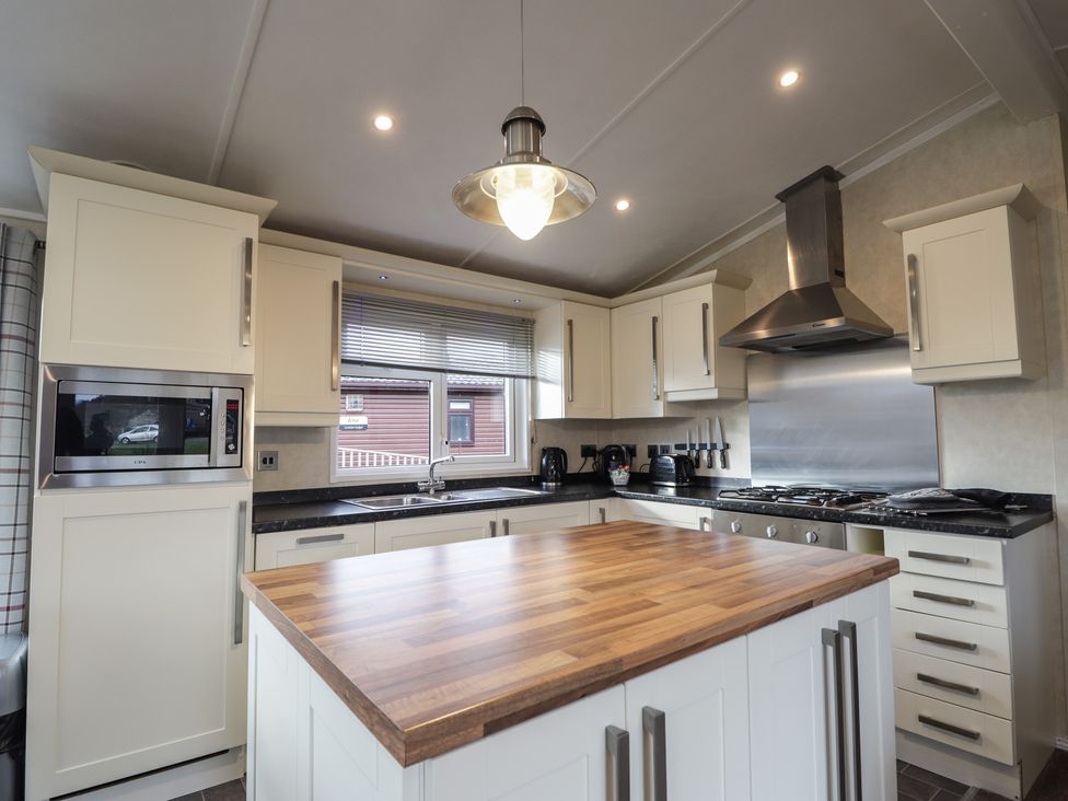 A kitchen with a wooden island and stainless steel appliances at Monach 1 in 