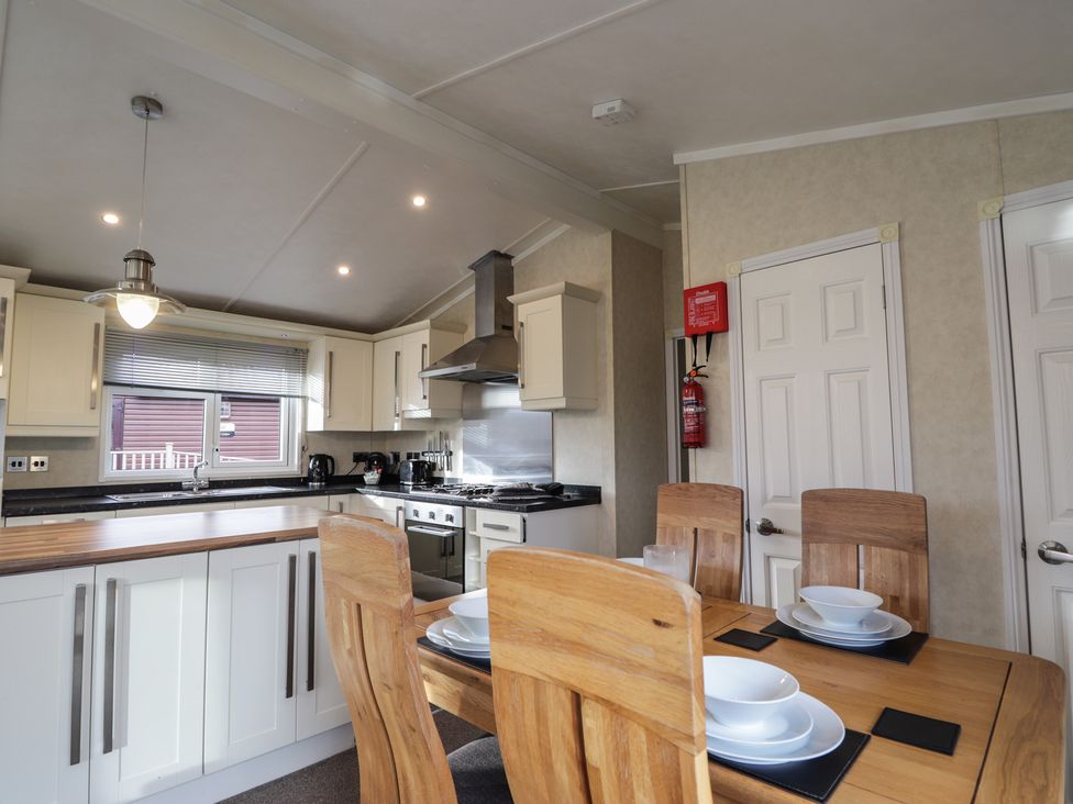A kitchen with a dining table and chairs at Monach 1 