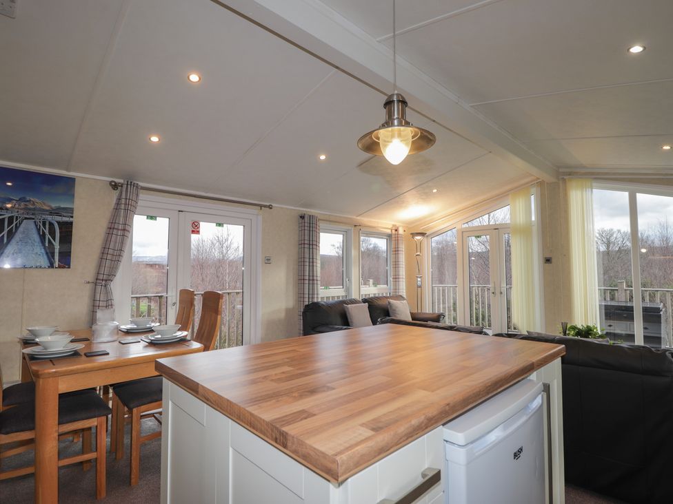 A living room with a dining table and chairs at Monach 1 