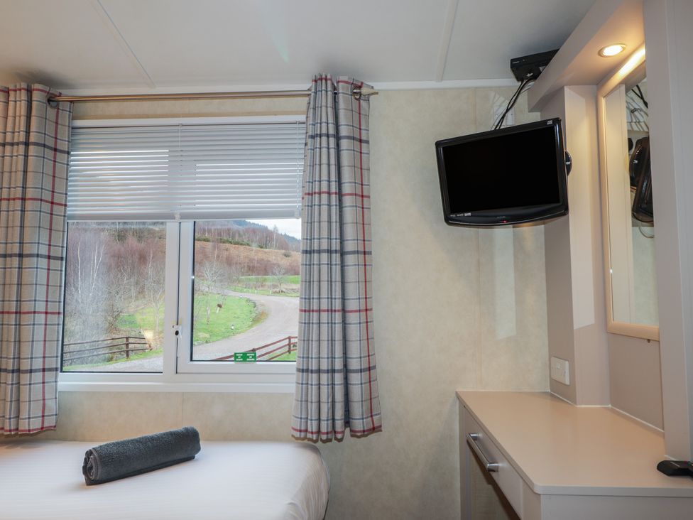 A bedroom with a window, tv, and bed at Monach 1