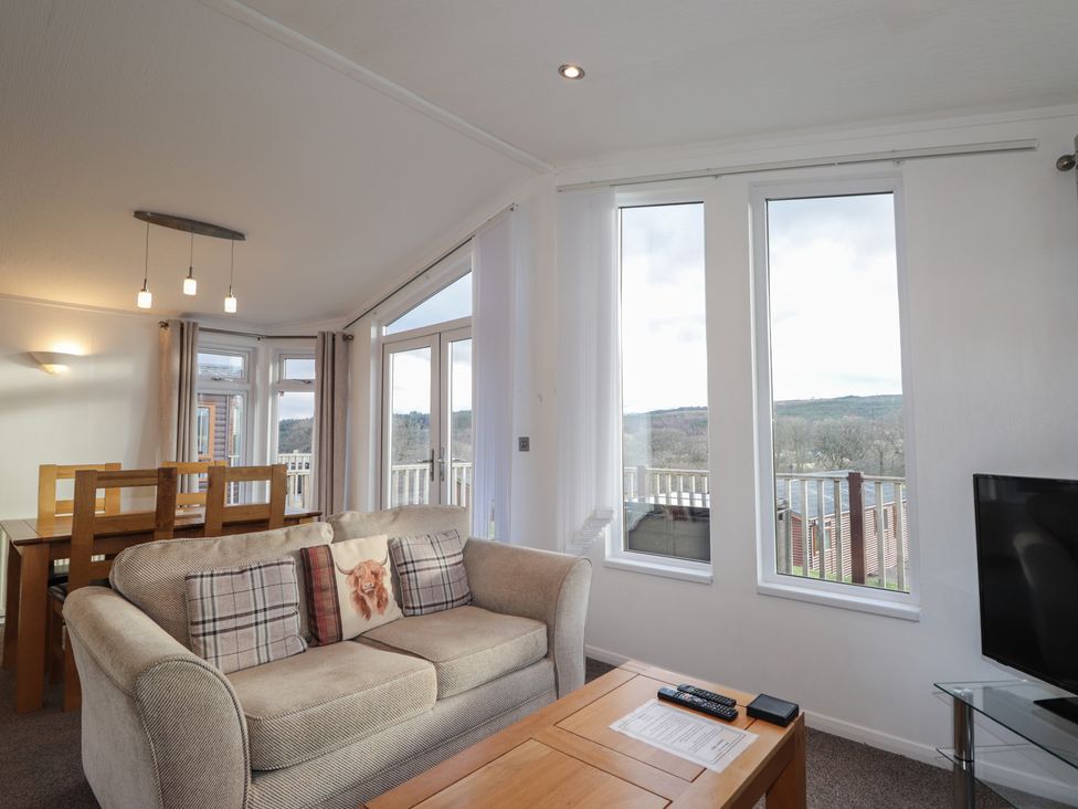 A living room with sofa, coffee table and large windows at Colonsay