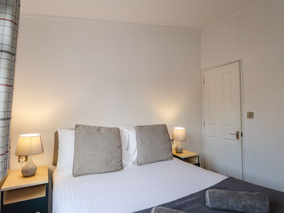 A bedroom with a bed and bedside tables at Colonsay