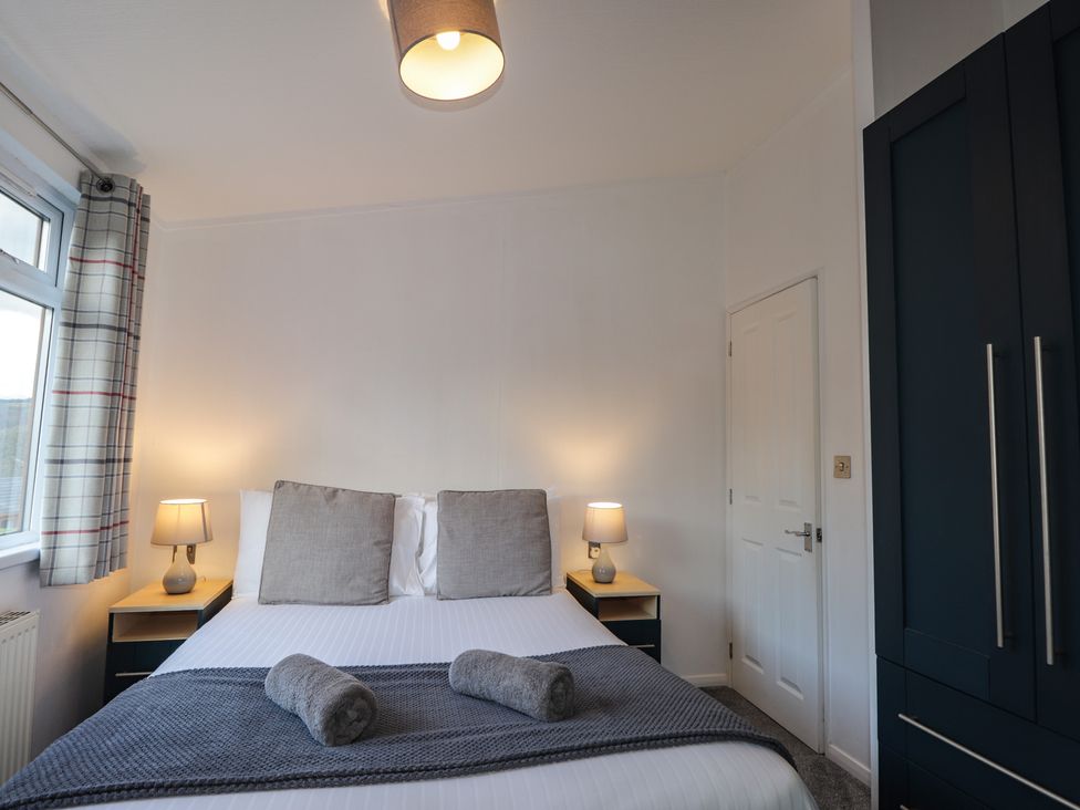A bedroom with a bed and bedside tables at Colonsay