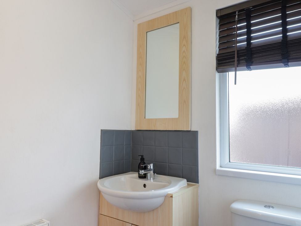 A bathroom with a sink and mirror at Colonsay