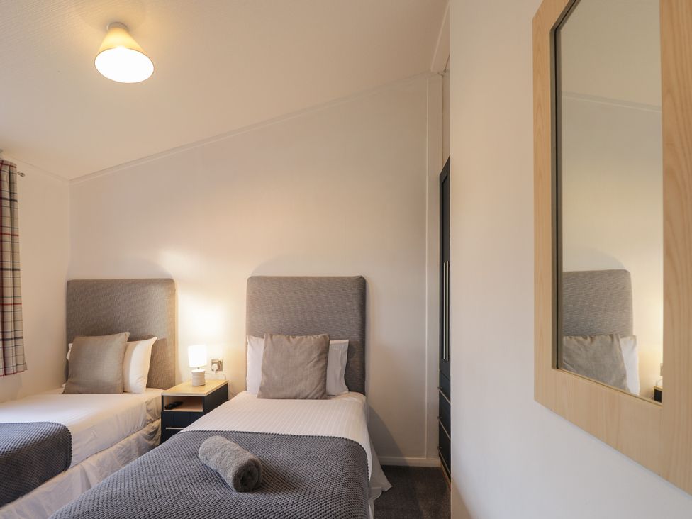 A bedroom with two beds and a mirror at Colonsay