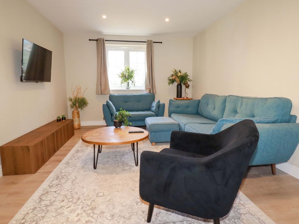 A living room with a sofa, coffee table, and television at 3 Rope Walk St. Austell