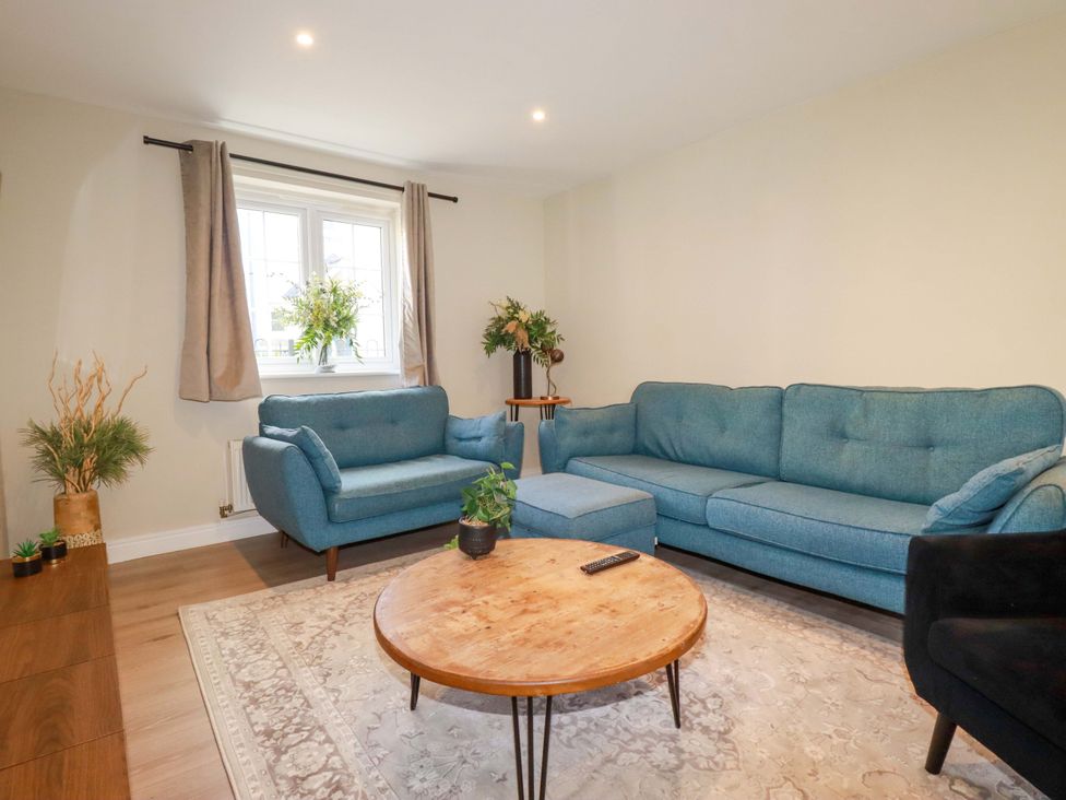 A living room with a blue sofa and a coffee table at 3 Rope Walk, St. Austell