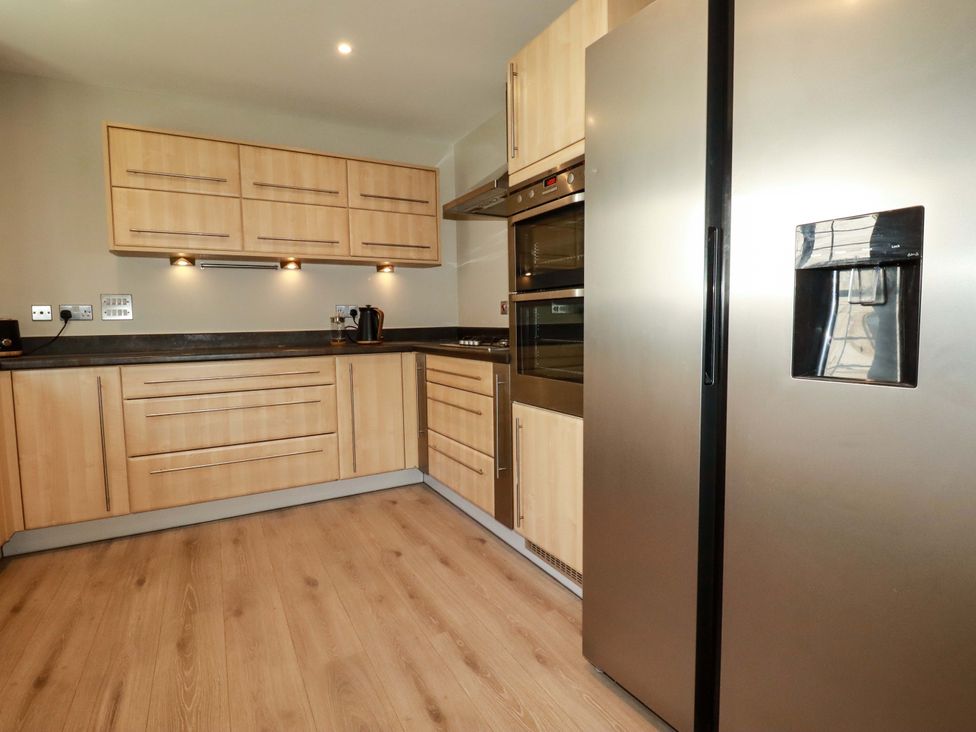 A kitchen with cabinets and appliances at 3 Rope Walk in St. Austell