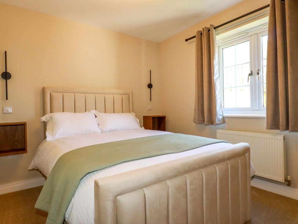 A bedroom with a bed and curtains at 3 Rope Walk in St. Austell