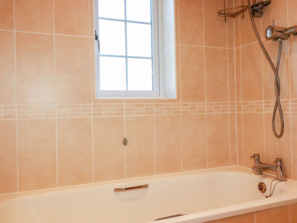 A bathroom with a bathtub and showerhead at 3 Rope Walk St. Austell