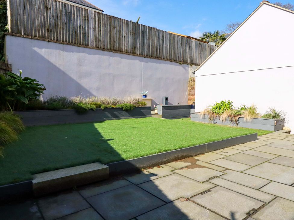 A garden with grass and planters at 3 Rope Walk in St. Austell
