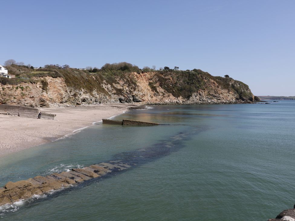 A beach view with water and cliffs at 3 Rope Walk in Duporth near Charlestown