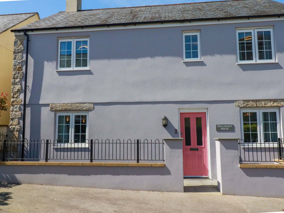 A house with a pink door and sign at Trelawney House Duporth near Charlestown