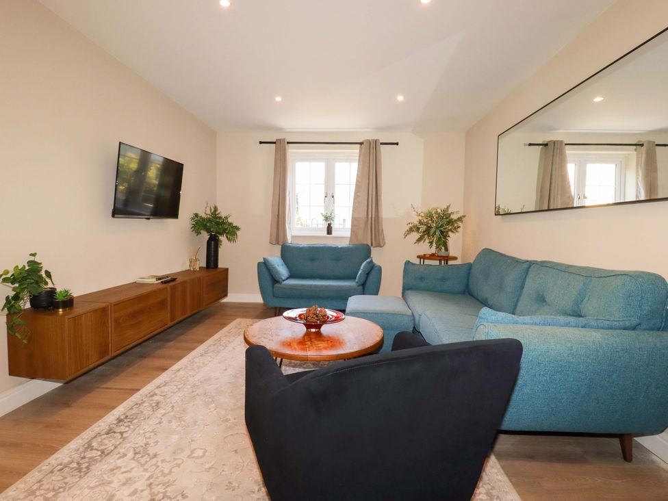 A living room with a sofa and television at Trelawney House in Duporth near Charlestown