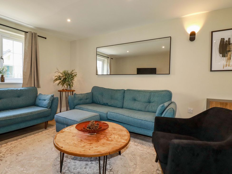 A living room with a sofa and coffee table at Trelawney House in Duporth near Charlestown