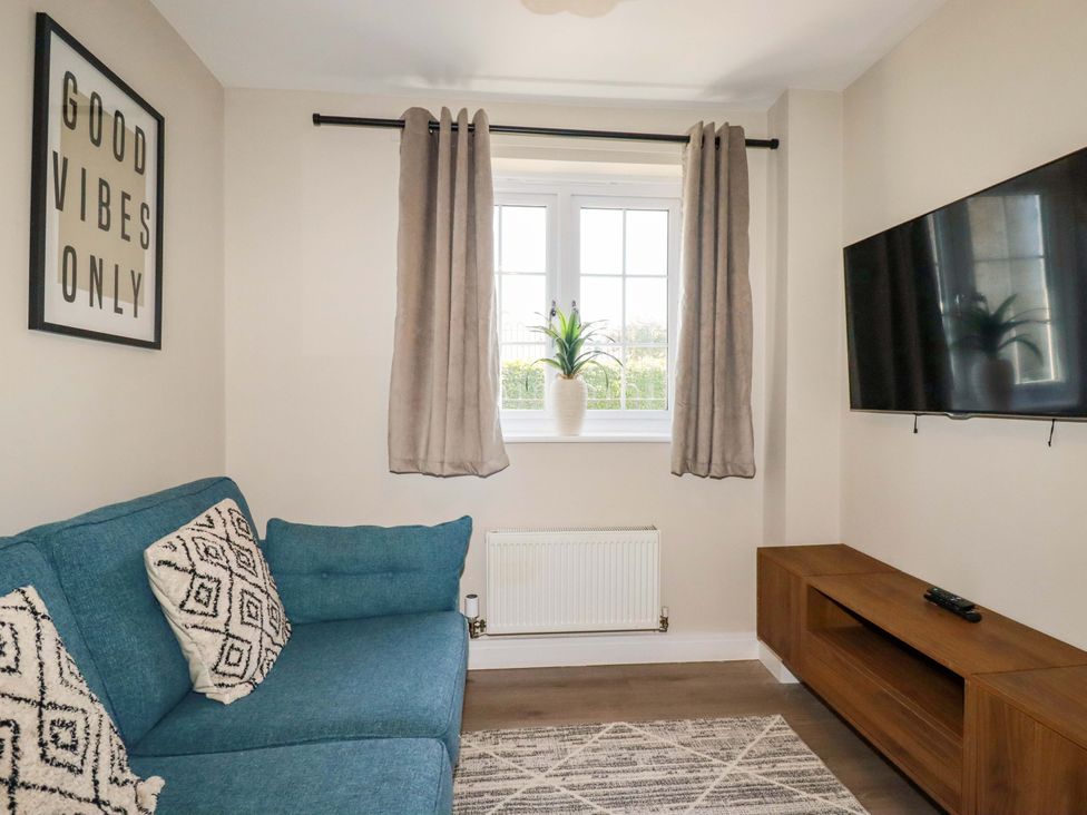 A living room with a sofa and television at Trelawney House in Duporth near Charlestown