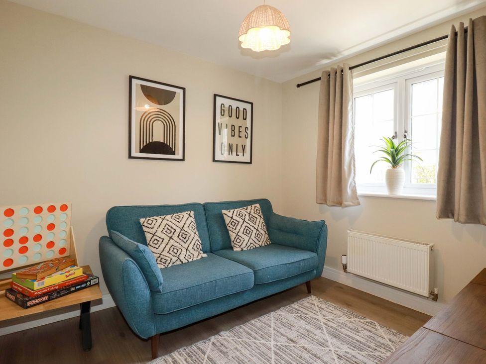 A living room with a sofa and wall art at Trelawney House Duporth near Charlestown