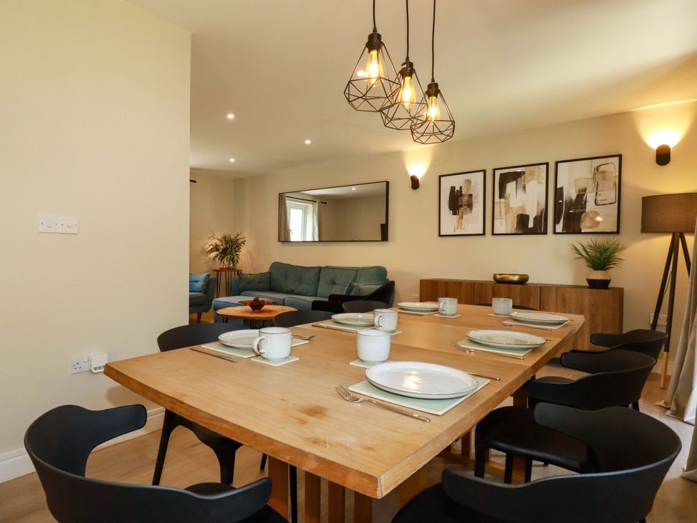 A dining room with a table set for meals at Trelawney House in Duporth near Charlestown