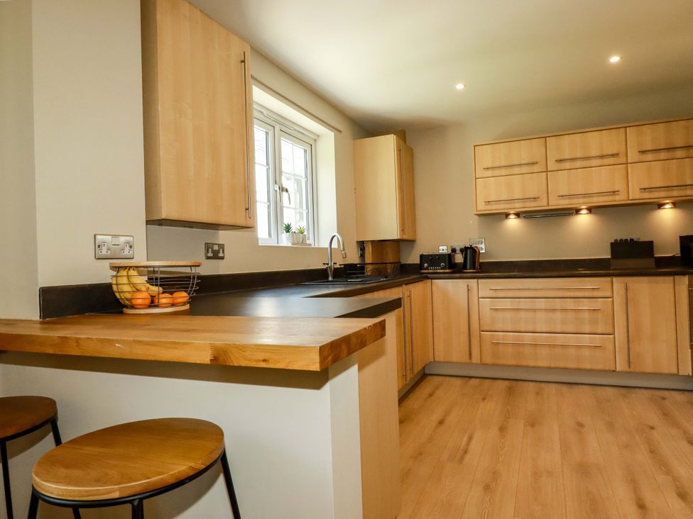 A kitchen with wooden cabinets and a countertop at Trelawney House Duporth near Charlestown