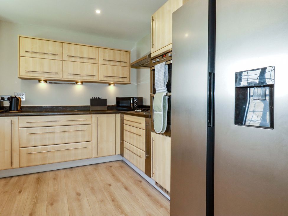 A kitchen with cabinets and appliances at Trelawney House Duporth near Charlestown