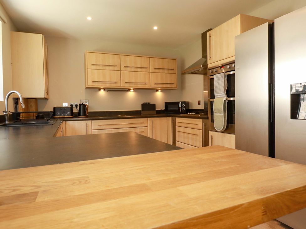 A kitchen with cabinets and appliances at Trelawney House Duporth near Charlestown