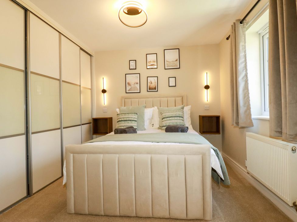 A bedroom with a bed and wall art at Trelawney House Duporth near Charlestown