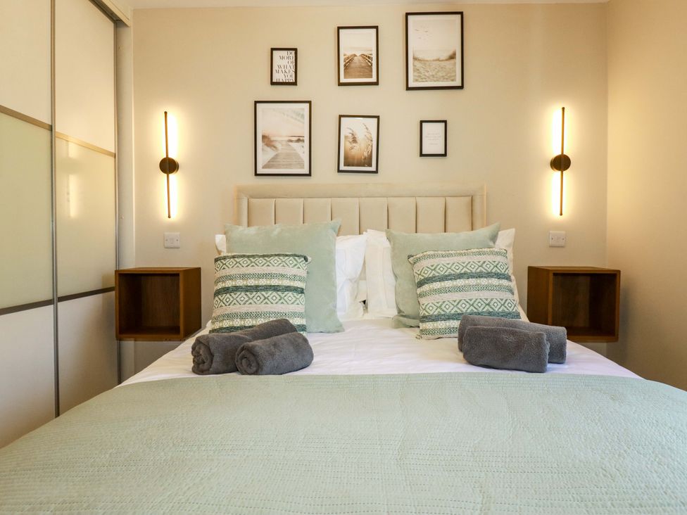 A bedroom with a bed and wall art at Trelawney House in Duporth near Charlestown