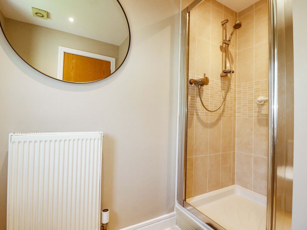 A bathroom with a shower and a mirror at Trelawney House Duporth near Charlestown