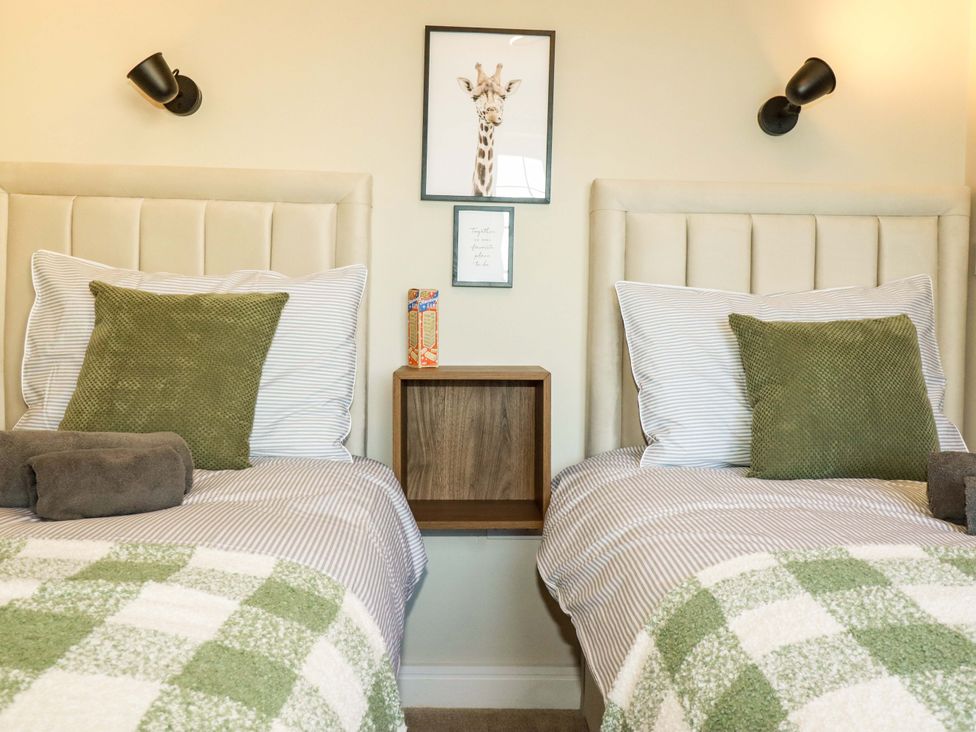 A bedroom with two beds and wall art at Trelawney House Duporth near Charlestown