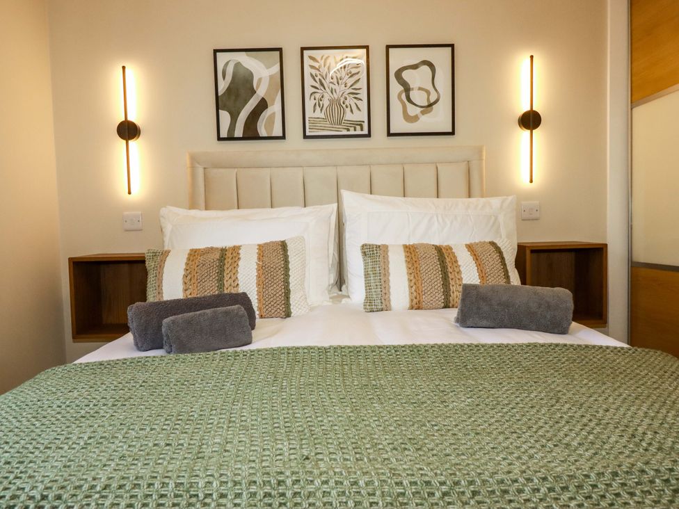A bedroom with a bed and wall art at Trelawney House Duporth near Charlestown