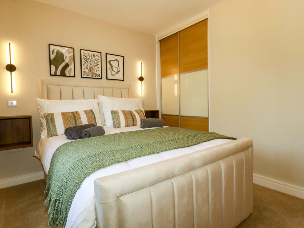 A bedroom with a bed and bedside tables at Trelawney House in Duporth near Charlestown