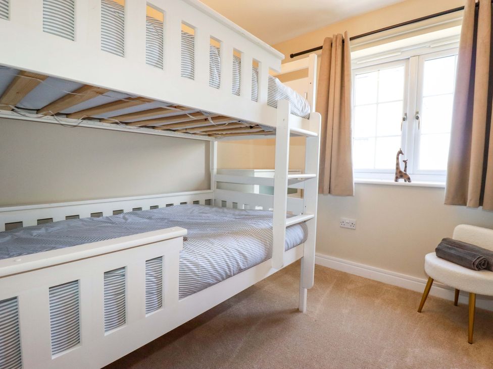 A bunk bed with striped bedding in a bedroom at Trelawney House Duporth near Charlestown