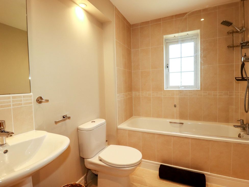 A bathroom with a bathtub, sink, and toilet at Trelawney House in Duporth near Charlestown