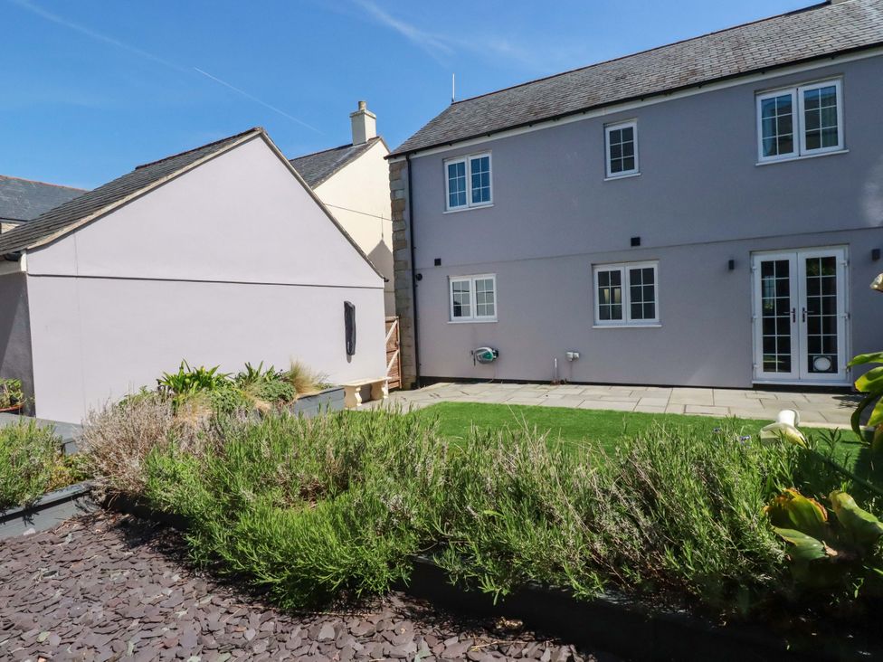 A garden with a house and greenery at Trelawney House Duporth near Charlestown