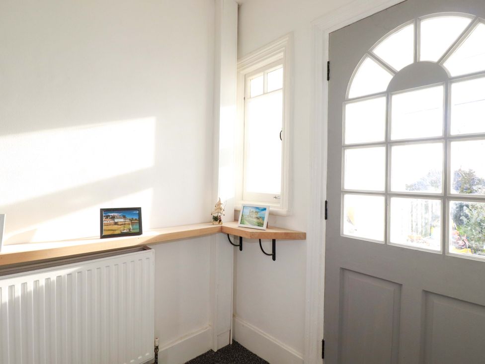 A hallway with a shelf and photographs at 39 Trevarthian road St Austell