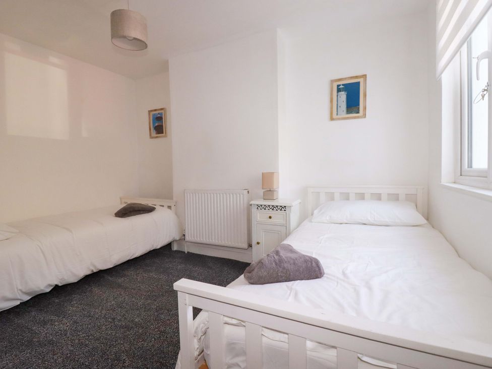 A bedroom with two beds and a lamp at 39 Trevarthian road St Austell