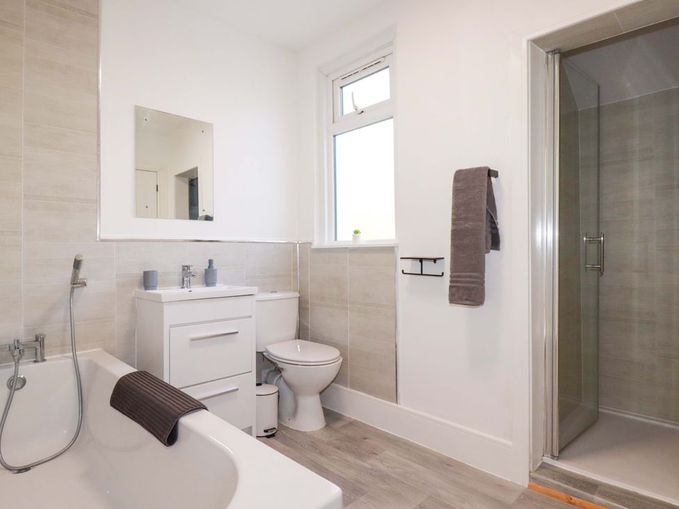 A bathroom with a bathtub, shower, toilet, and sink at 39 Trevarthian road St Austell