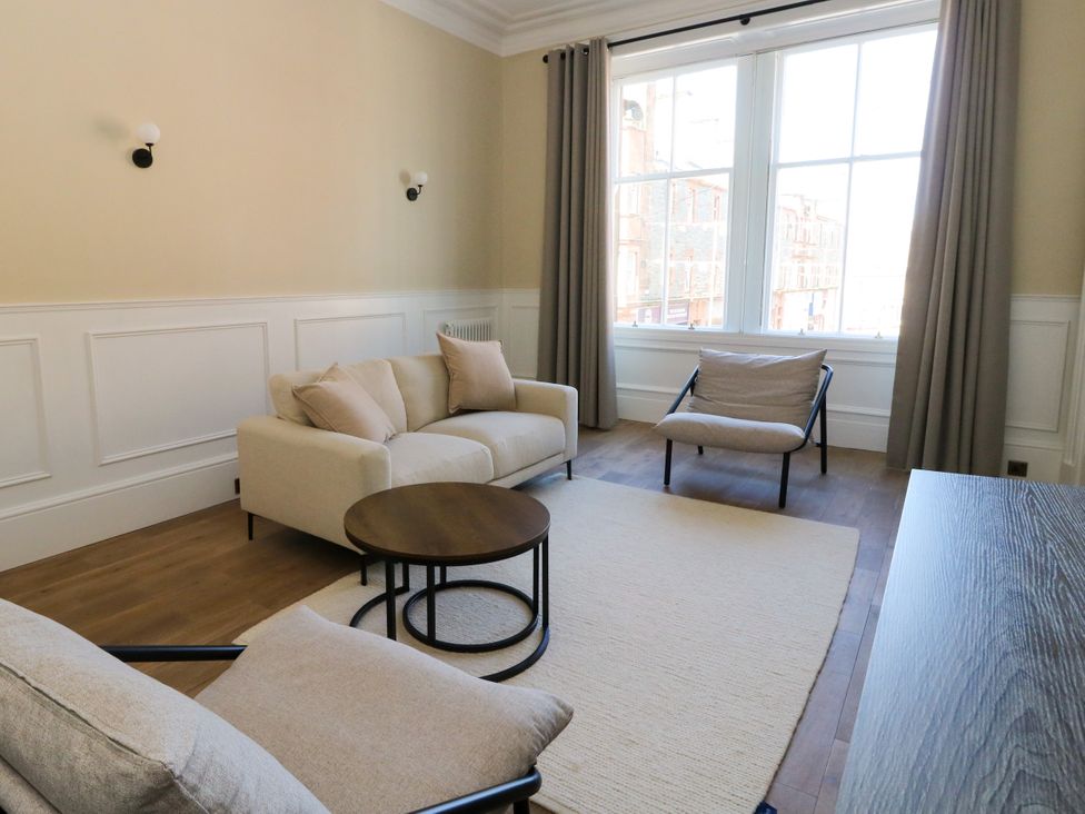 A living room with seating and a coffee table at Flat 1