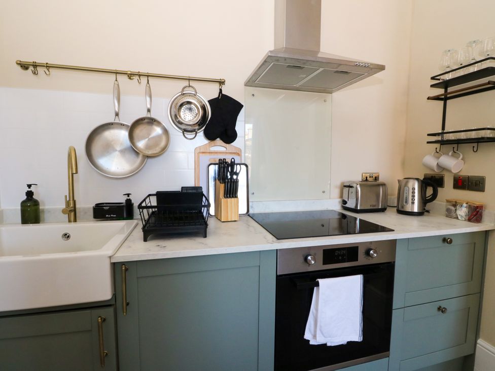 A kitchen with sink and cooking appliances at Flat 1