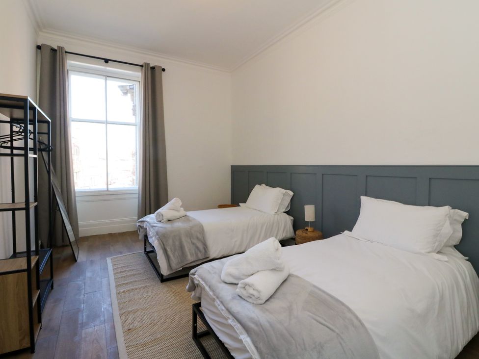 A bedroom with two beds and a window at Flat 1