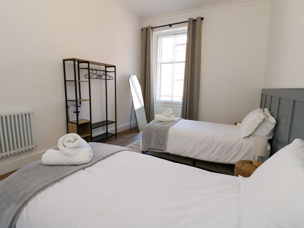 A bedroom with two beds and a window at Flat 1