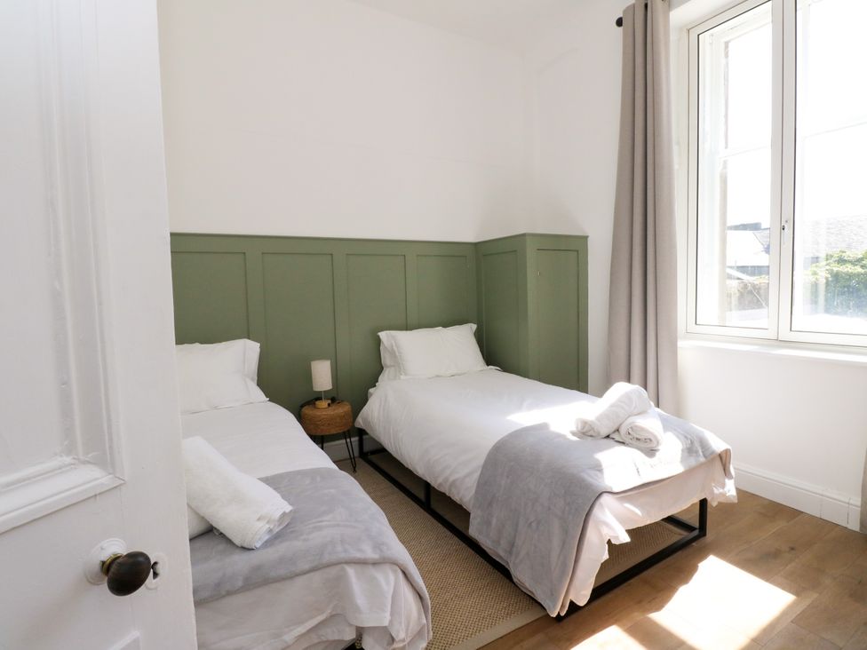 A bedroom with two beds and a green wall at Flat 1